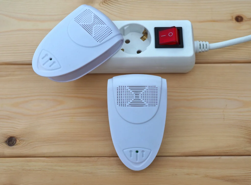 Two ultrasonic pest repeller devices plugged into a power strip.