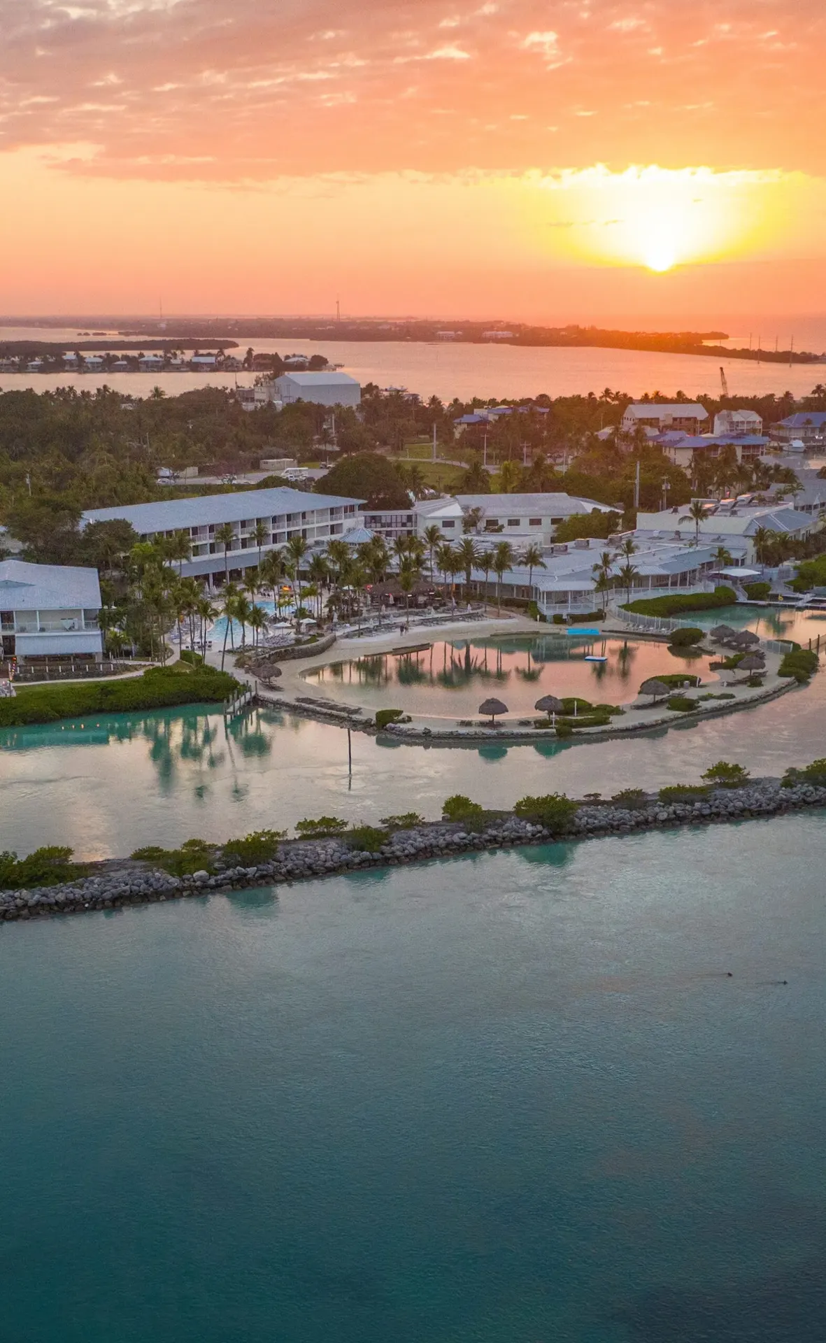 Pest control Coconut Creek aerial sunset view of Florida lagoon resort community with palm trees and turquoise water